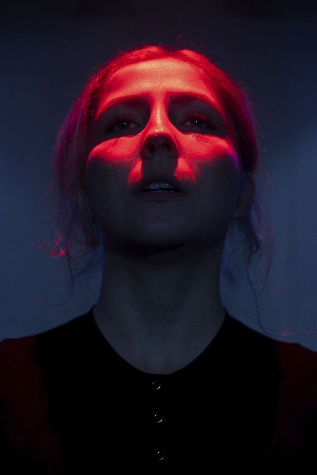 Caroline Marre dans La fille de Déméter, le visage éclairé de rouge.